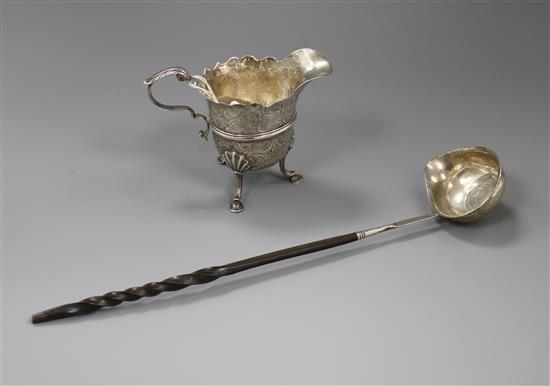 A Georgian Irish silver cream jug (a.f.) and a white metal toddy ladle.